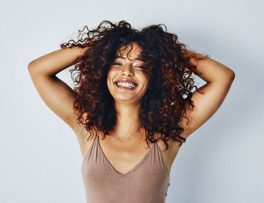 femme-aux-cheveux-boucles-long-bruns-volumineux-saison-des-pluies