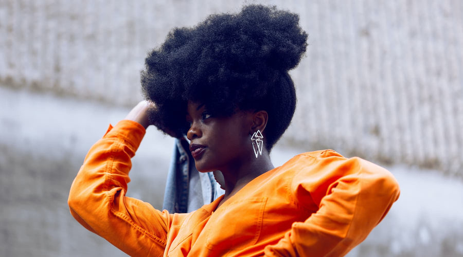 femme noire aux cheveux crépus portant un afro puff sur le devant de la tête saison des pluies