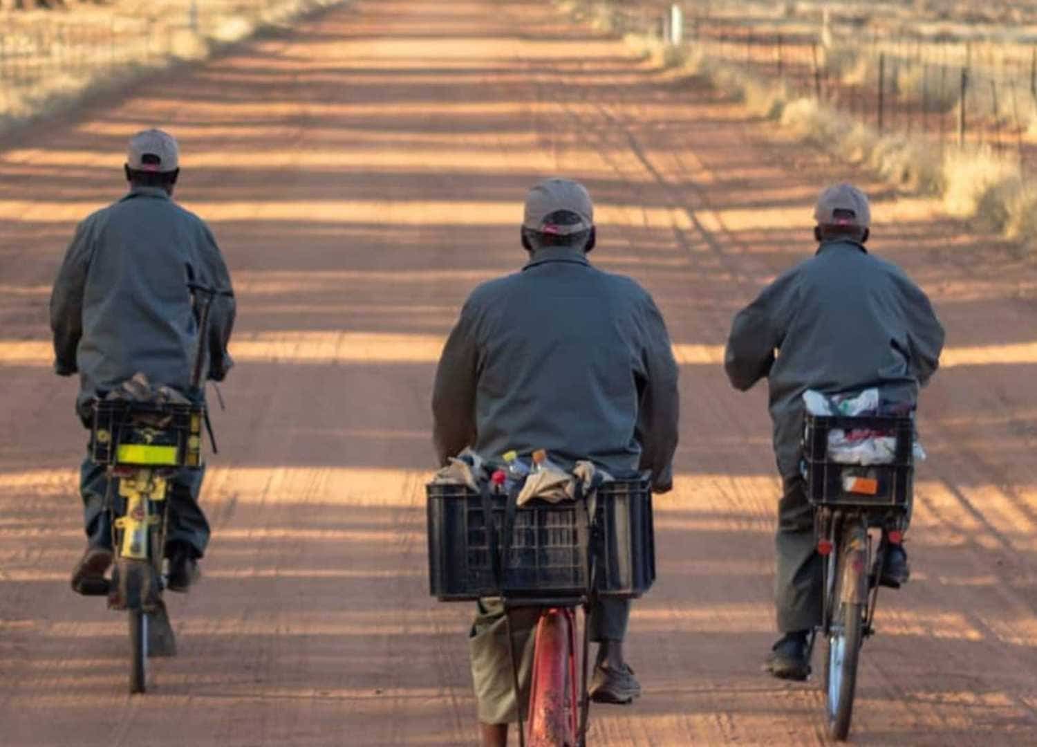 Trois hommes africains en bicyclette sur un chemin en Afrique du Sud