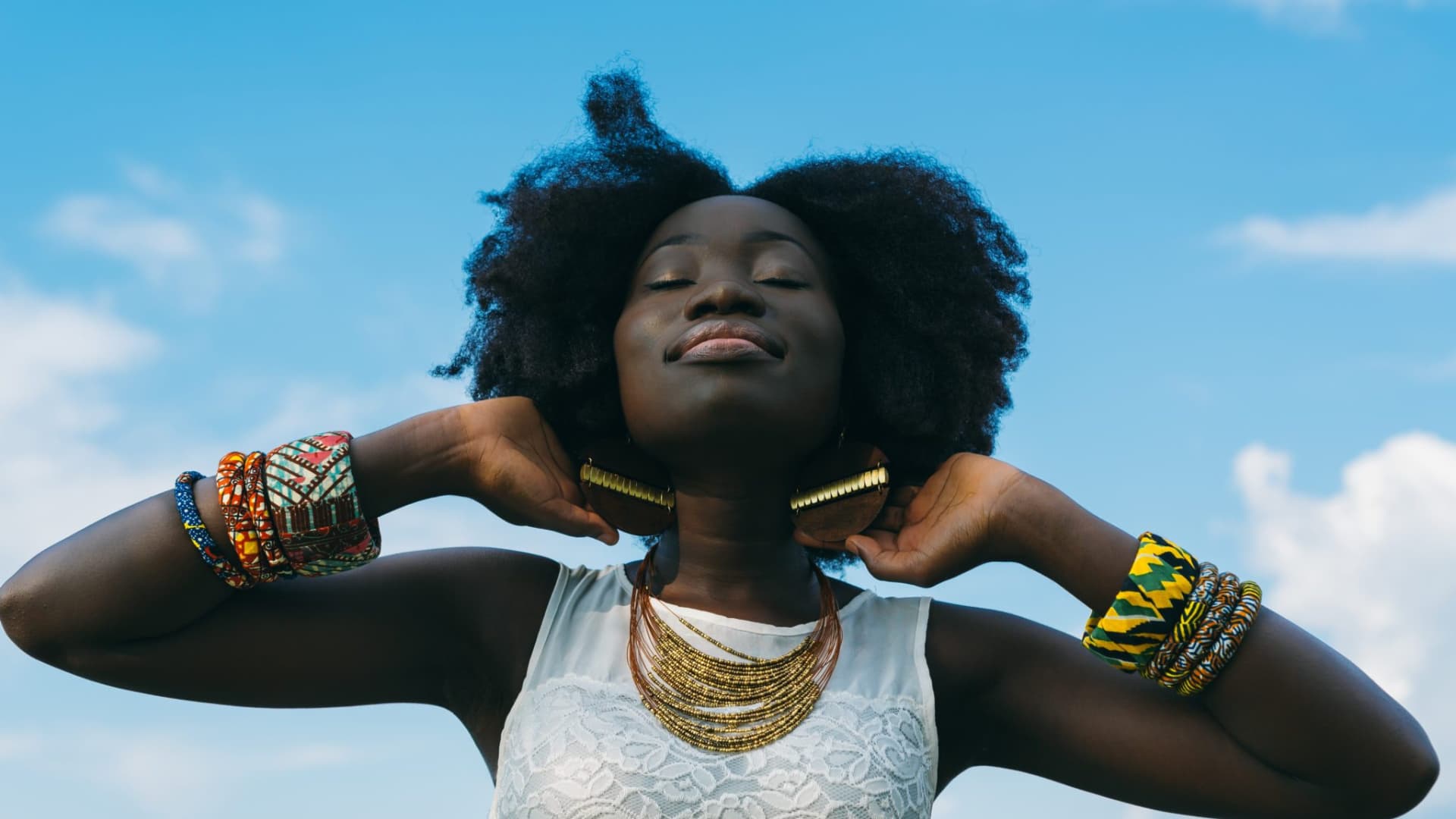 femme africaine au cheveux crépu naturel tête levée vers le ciel