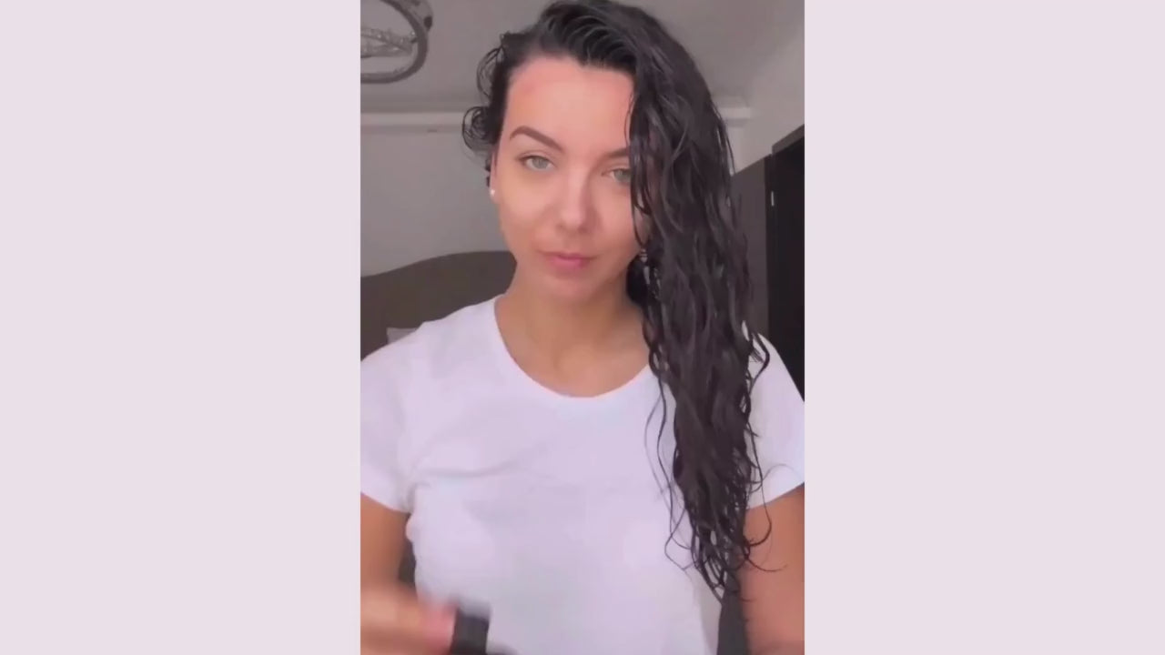 femme aux cheveux ondulés qui définit ses boucles ondulations à l'aide du spray hydratant leave in So Wet Oh! de la marque saison des pluies spray cheveux hydratant pour femmes aux cheveux bouclés frisés afros ondulés
